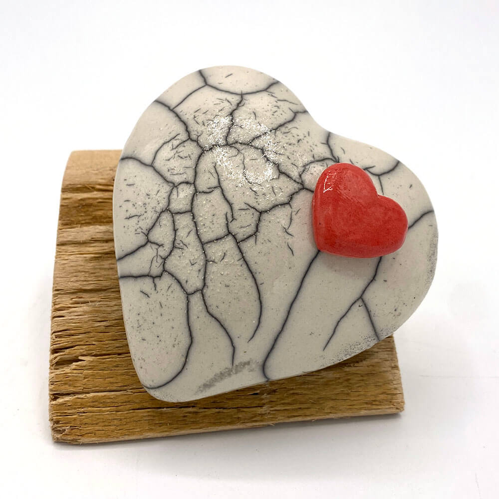 mini urn in de vorm van een hartje met rood afdichtdekseltje
