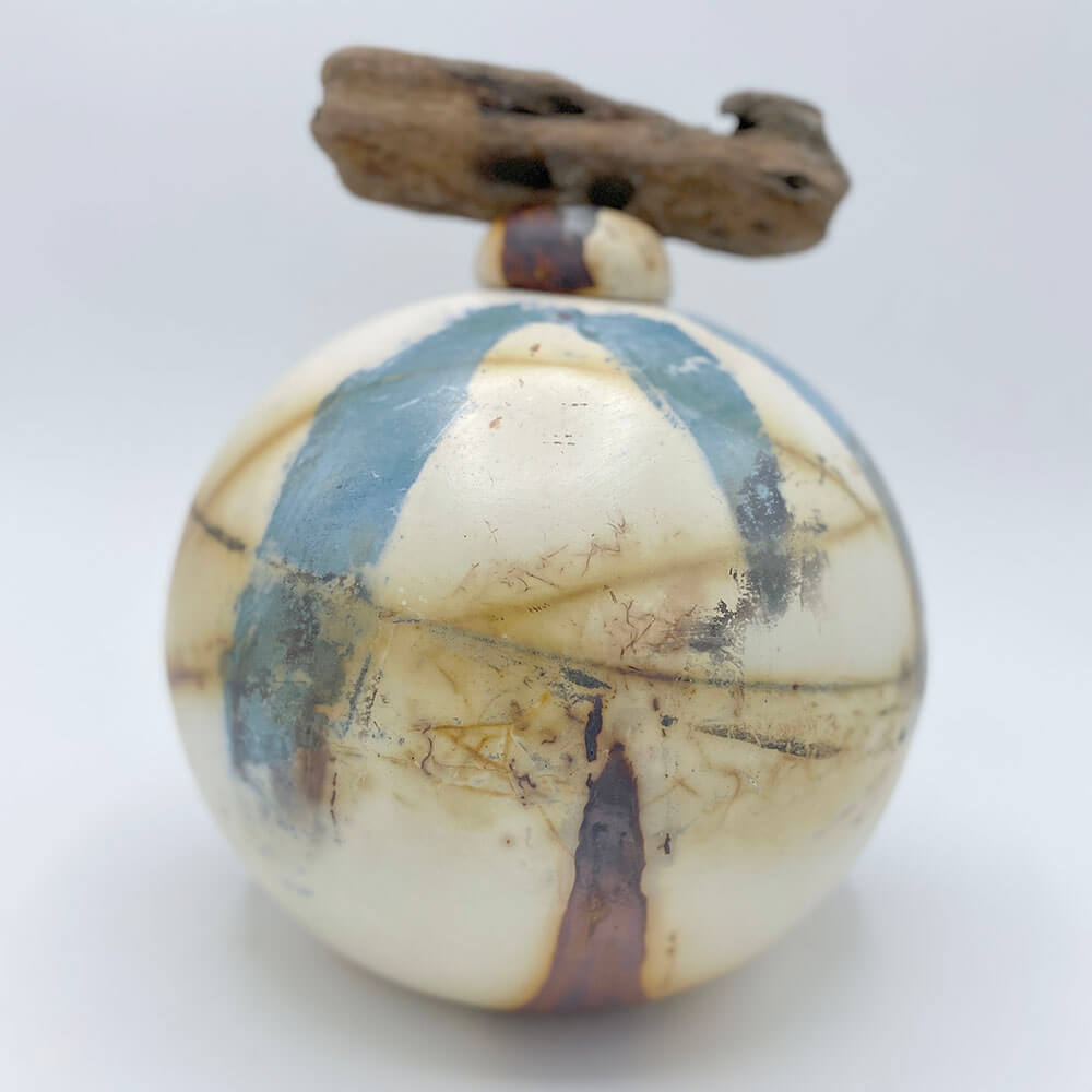 keramieke ronde bol urn met natuurlijke kleuren en strandhout afgewerkt